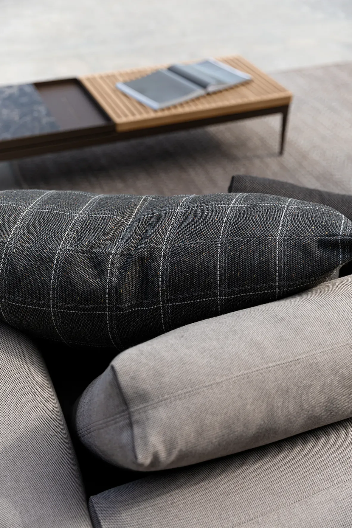 close up showing detail of grid seating with a variety of cushions and coffee table in the background