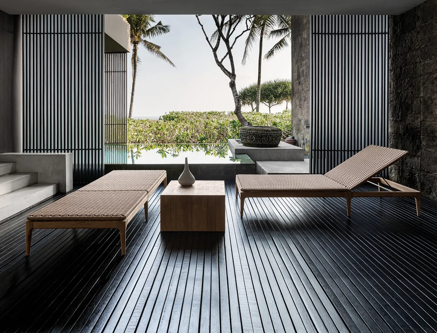 two lima loungers in a spa setting with a pool behind