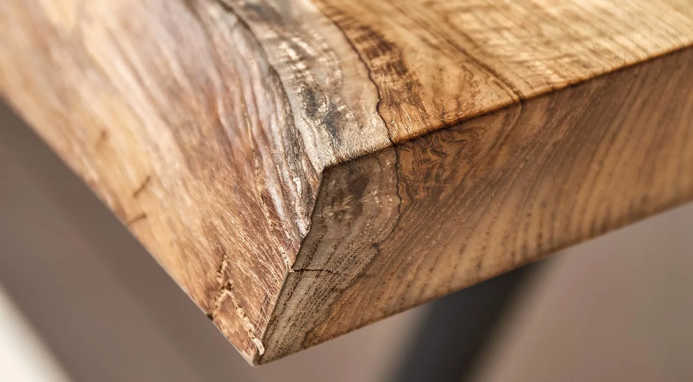 A single teak slab on the workshop floor, viewed from overhead.