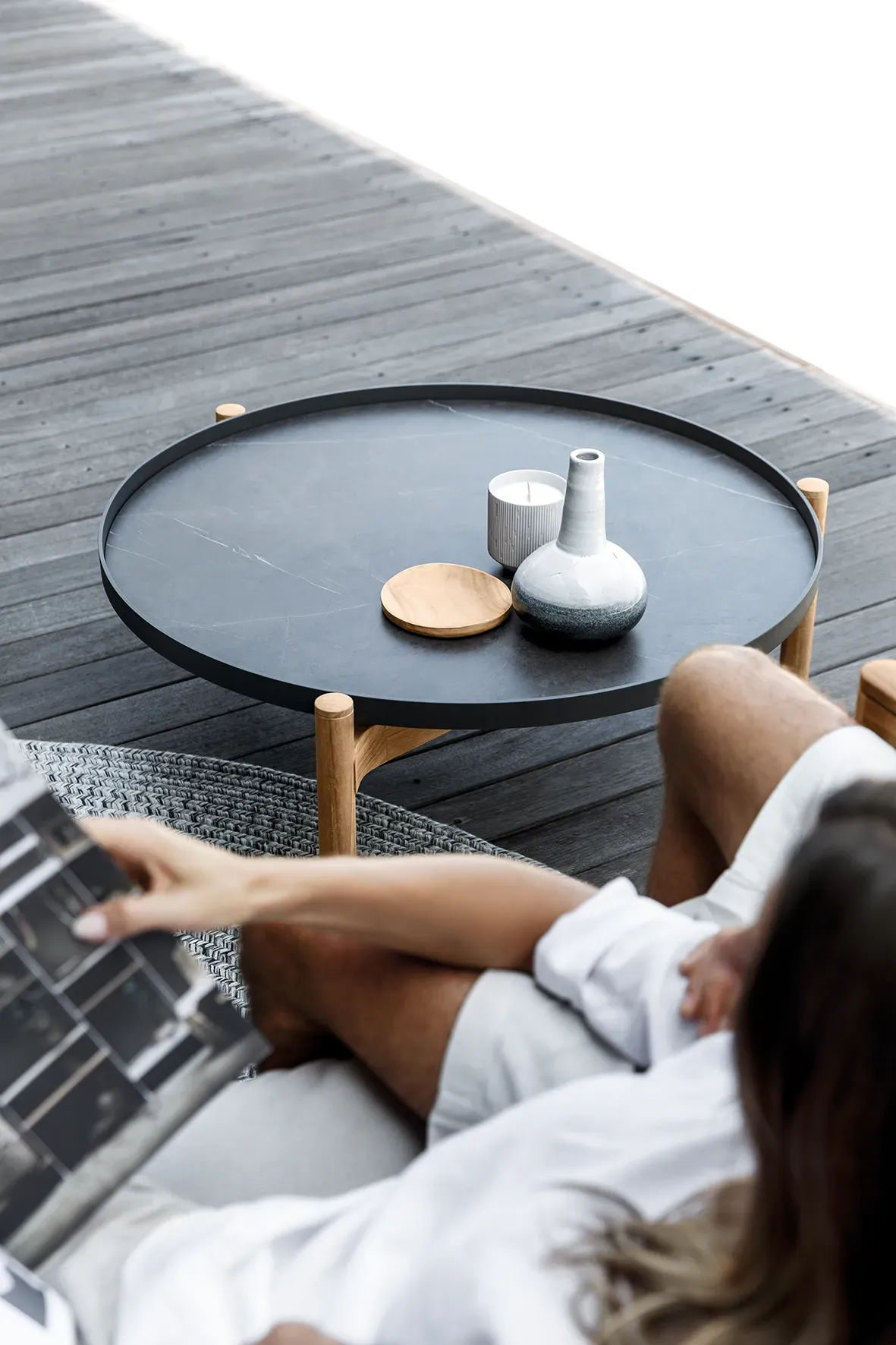 close up of woman seated with deco rug and detail of sepal coffee table