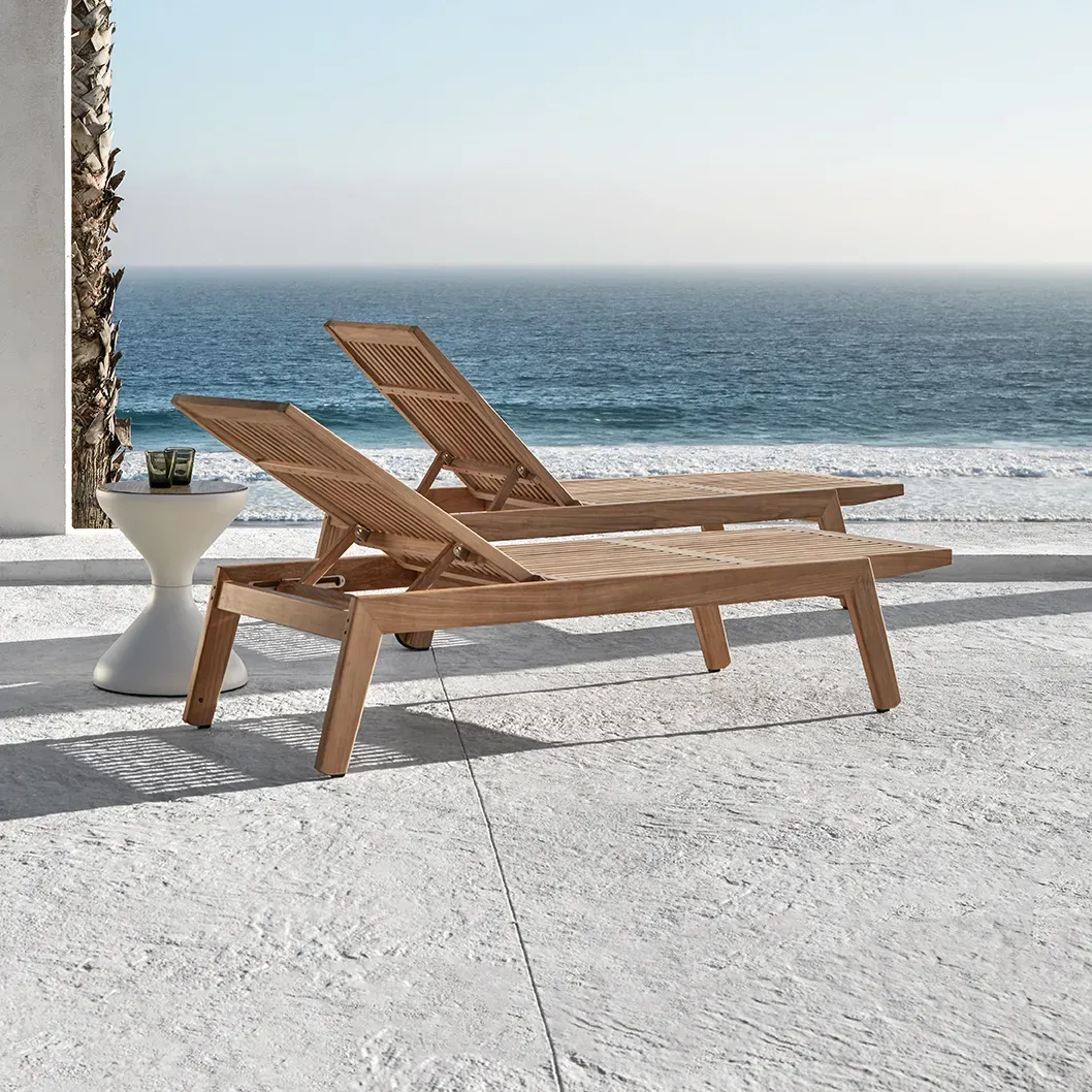two solana teak loungers at a coastal property with sea and sky behind